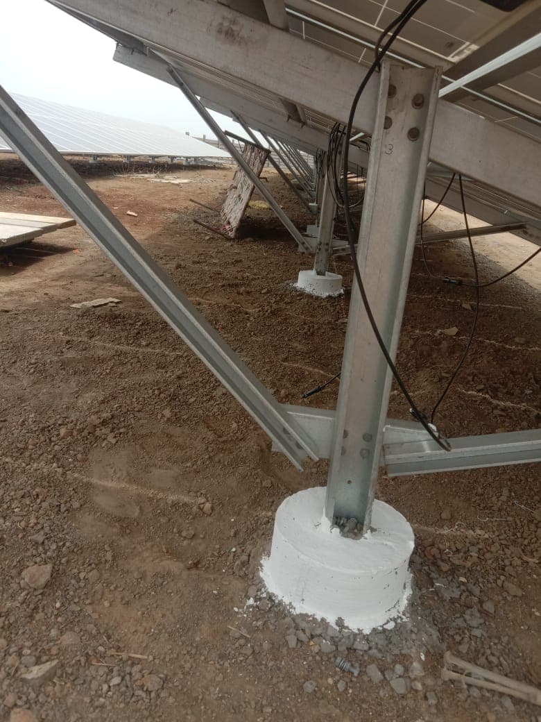 Galvanised steel column of a solar mounting structure anchored in a round concrete footing